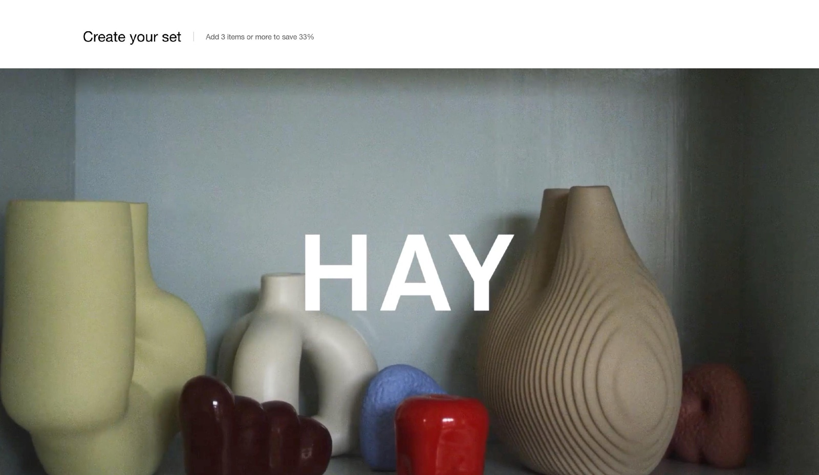 Storefront Media with text overlay section with the heading "Create your set" and a full-width video card of colourful vases with the white title HAY over it.